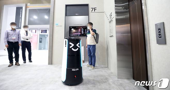 '2021 한국국제승강기엑스포'에서 현대엘리베이터 관계자가 배달의민족 배달로봇 딜리 시연을 하고 있다./사진=뉴스1