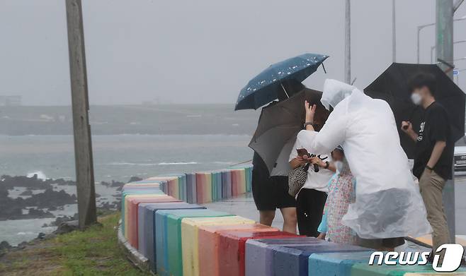제14호 태풍 '찬투(CHANTHU)'가 북상 중인 14일 오전 제주시 용담해안도로에서 우산을 쓴 행인들이 발걸음을 옮기고 있다. 2021.9.14/뉴스1 © News1 오현지 기자