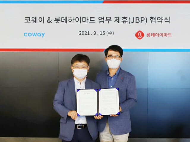롯데하이마트와 코웨이가 15일 오전 서울 구로구 G타워에서 전략적 비즈니스 파트너십(JBP)를 체결했다. 협약식에서 롯데하이마트 맹중오 상품본부장(우)와 코웨이 이지훈 2사업본부장이 기념 촬영을 하고 있다. (사진=롯데하이마트)