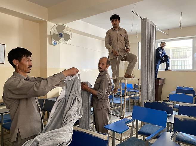 아프간 대학 강의실에 남녀를 구분하는 커튼을 설치하는 모습.