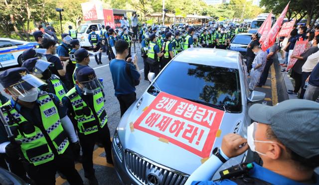 15일 오후 서울 여의도 국회 앞에서 한국유흥음식업중앙회 소속 업주들이 주최한 집합금지 해제 촉구 차량시위에서 경찰이 차량행진를 통제하고 있다. 뉴스1