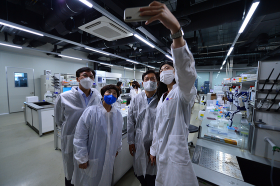 Song Young-gil, head of the ruling Democratic Party, second from right, poses with researchers at SK Bioscience's R&D center in Seongnam, Gyeonggi to show support for their study into Covid-19 vaccines. [YONHAP]