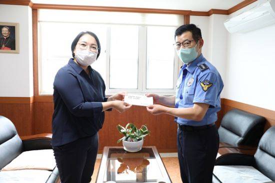 (우측)이재현 서해지방해양경찰청 기획운영과장이 목포 명도복지관 최미진 관장에게 전달하고 있다. ⓒ 아시아경제