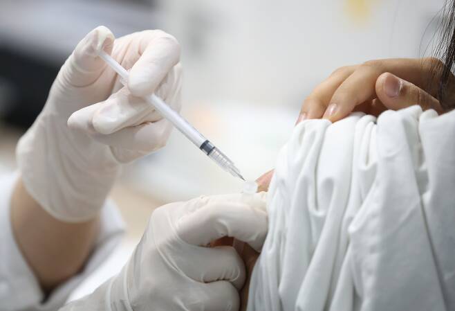 7일 오후 서울 마포구민체육센터에 마련된 코로나 예방접종센터에서 의료진이 화이자 백신을 접종하고 있다./연합뉴스