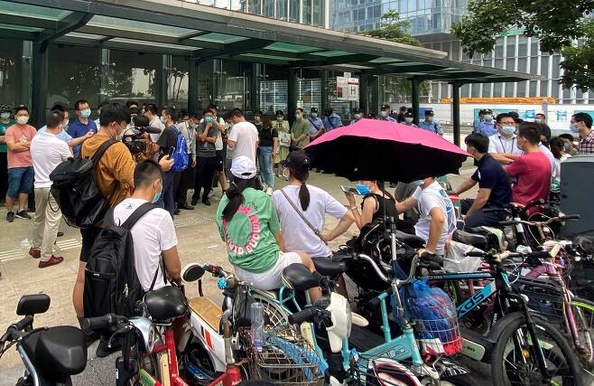 15일 중국 광둥성 선전에 있는 대형 민간 부동산 개발업체 헝다(恒大·에버그란데) 그룹 본사 앞에 보안요원들이 배치된 가운데 투자자들이 몰려들어 돈을 돌려달라고 요구하고 있다.