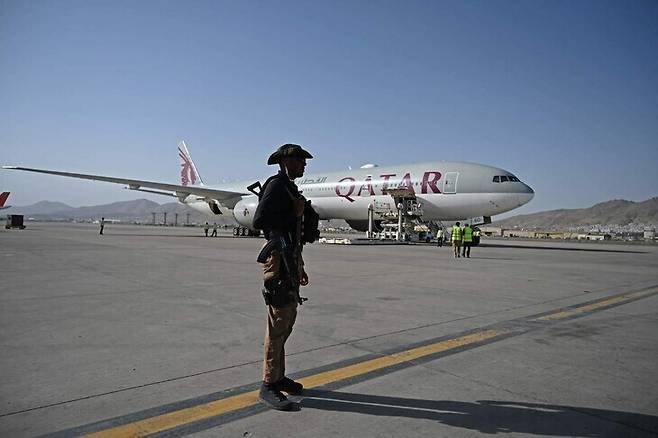 미국의 아프가니스탄 철수 이후 첫 외국인 대규모 출국을 돕기 위해 9월9일(현지시각) 카불 공항에 도착한 카타르 민간 항공기 앞에 보안요원 한 명이 서 있다. 카불/AFP 연합뉴스