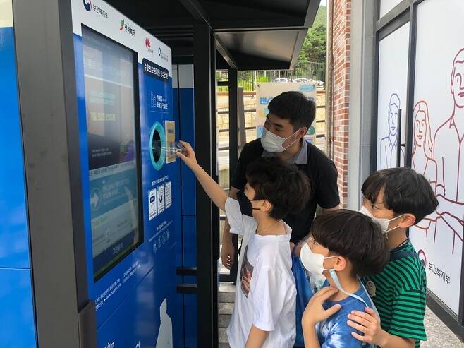 자판기 형태의 순환자원 회수로봇을 통해 어린이들이 페트병을 넣어 체험하고 있다. 전주시 제공