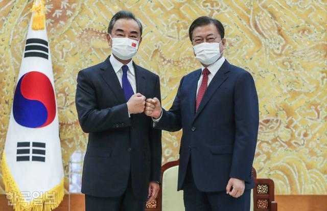 문재인(오른쪽) 대통령이 15일 청와대에서 왕이 중국 외교부장을 접견하기 전 주먹 인사를 하고 있다. 왕태석 선임기자