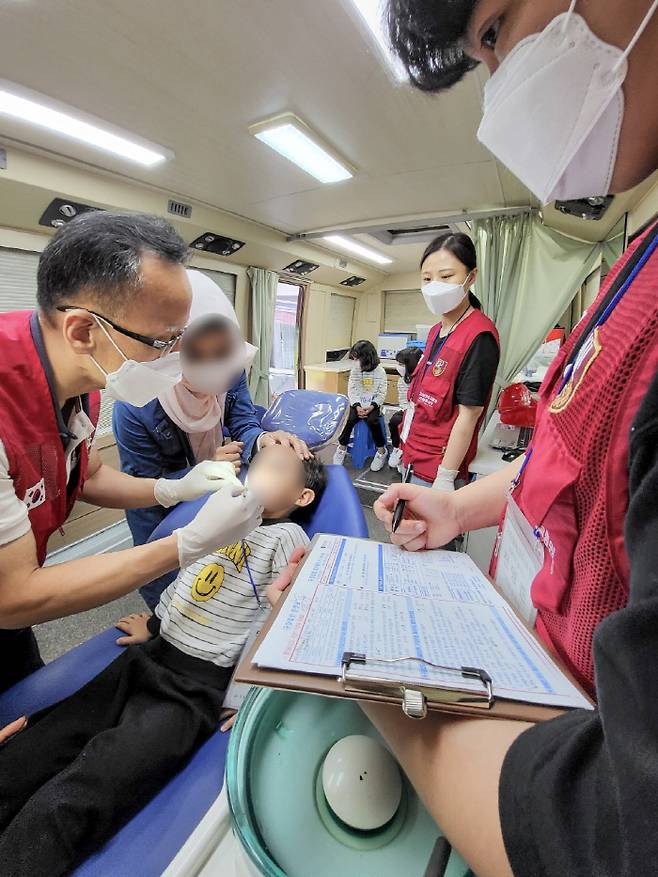 고려대 안암병원 치과 최연조 교수가 아프간 어린이를 진료하고 있다.