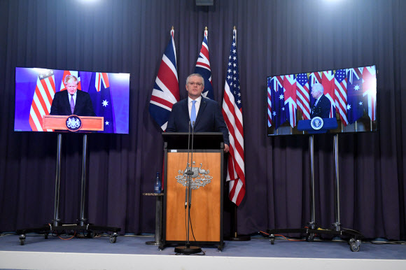 15일(현지시간) 스콧 모리슨 호주 총리(가운데)가 조 바이든 미국 대통령, 보리스 존슨 영국 총리와 함께 공동 화상 회견을 열어 '오커스'(AUKUS)로 불리는 3자 안보 동맹 구축을 발표하고 있다. 캔버라=EPA연합