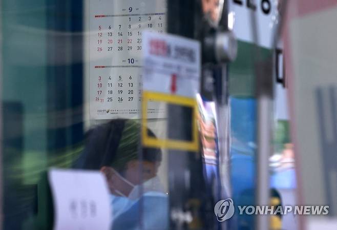 선별진료소의 달력 (서울=연합뉴스) 홍해인 기자 = 16일 오후 서울 동작구 보건소 코로나19 선별검사소 접수 창구 관계자 너머로 사무실 벽에 추석 연휴를 알리는 달력이 부착돼 있다.
이번 추석 연휴(9.19∼22)에도 보건소 등 전국 의료기관에서는 신종 코로나바이러스 감염증(코로나19) 정규 선별진료소 및 임시 선별검사소를 운영하며 진단 검사도 계속 시행한다. 연휴 기간 이동 인구가 많은 터미널과 역 등에도 임시 선별검사소가 추가로 설치된다.2021.9.16 hihong@yna.co.kr