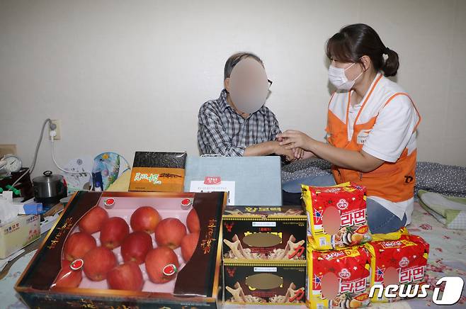 지난 16일 오후 광주 서구 광천동 한 가정에서 이은숙 월드비전 무진종합사회복지관 과장이 독거노인에게 명절 선물 꾸러미를 전달하고 있다. 2021.9.18/뉴스1
