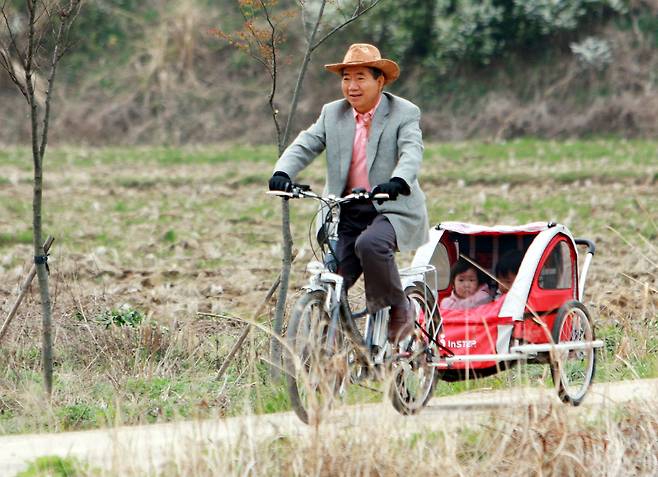 노무현 전 대통령이 2008년 4월 13일 자전거에 매단 수레에 손녀를 태우고 마을 주변을 달리고 있다. /연합뉴스