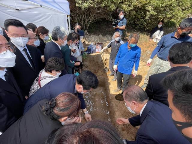 성도들이 하관예배 후 조용기 목사의 묘소에 국화 꽃잎과 흙을 뿌리고 있다.
