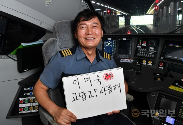 임수영 KTX 기장이 지난 8일 서울역에서 아내를 향한 메시지를 손에 든 채 활짝 웃고 있다.