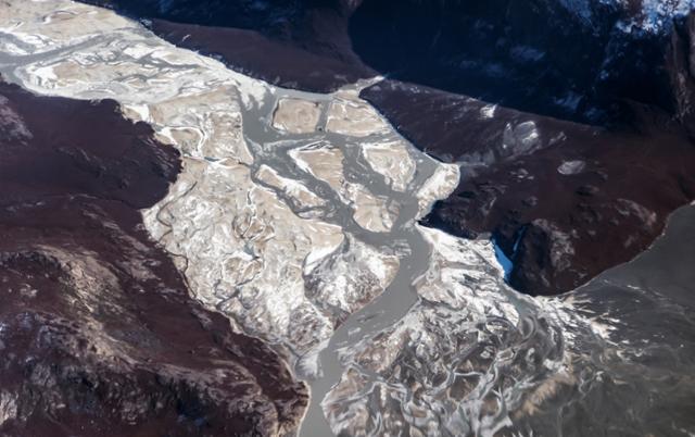 17일 그린란드 칸데를루수악에서 빙하가 녹은 물과 토양 뒤섞여 강물처럼 흘러내리고 있다. 칸게를루수악=로이터 연합뉴스