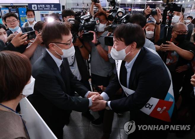 명절 인사 중 마주친 윤석열-최재형 (서울=연합뉴스) 홍해인 기자 = 국민의힘 윤석열(오른쪽), 최재형 대선 경선 예비후보가 추석 연휴를 맞아 19일 오전 서울역 대합실에서 각각 시민들에게 명절 인사를 하던 중 만나 악수를 하고 있다. 2021.9.19 hihong@yna.co.kr