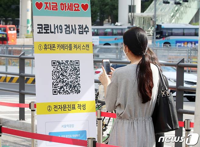 추석 연휴 셋째 날인 20일 오전 서울 중구 서울역 선별진료소에서 한 시민이 검사 전 전자문진표 작성을 위해 바코드를 스캔하고 있다. © News1 김진환 기자