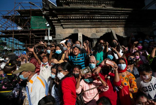 네팔 주민들이 옌야 축제의 일환으로 열리는 쿠마리의 연례 행차를 관람하기 위해 19일 카트만두 시내 거리에 모여 있다. 카트만두=AP 연합뉴스