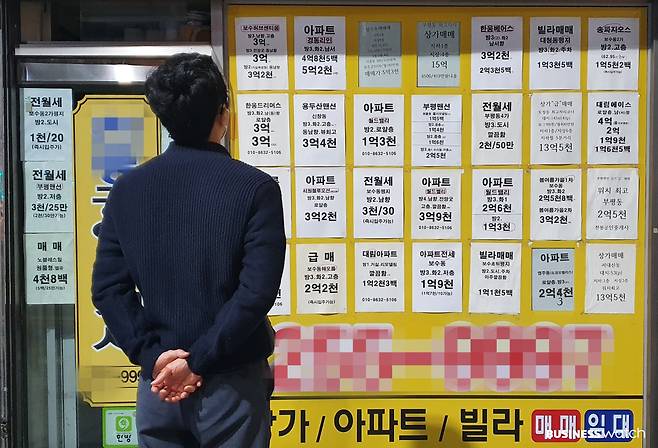 젊은 남성이 부동산 중개업소 앞에서 아파트 매물 가격을 보고 있다./채신화 기자