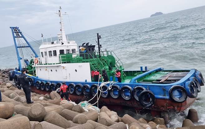 태안해경이 방파제에 최초된 예선 A호의 고박, 파공봉쇄, 유류이적 등 구난조치를 진행하고 있다. (사진=태안해경 제공) *재판매 및 DB 금지
