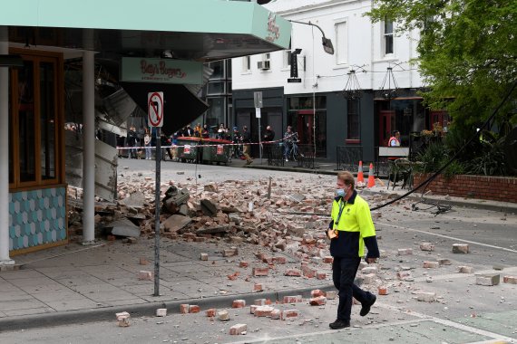 22일 규모 6.0 지진이 발생한 호주 멜버른 근교 윈저에서 한 시민이 잔해가 떨어진 거리를 지나가고 있다.로이터뉴스1