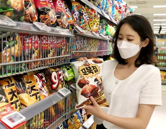 한 소비자가 마트에서 오리온 꼬북칩 초코츄러스맛을 살펴보고 있다. (사진=오리온)