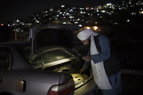 [16일(현지시간) 아프가니스탄 카불의 한 검문소에서 탈레반 병사가 자동차 짐칸을 조사하고 있다. 사진=뉴시스