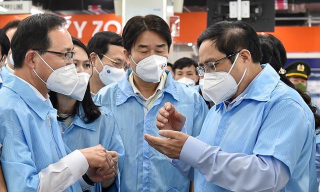 3일 팜민찐(오른쪽) 베트남 총리가 삼성 박닌 공장을 방문해 정부의 방역 기조 등을 설명하고 있다. 베트남 정부포털 캡처
