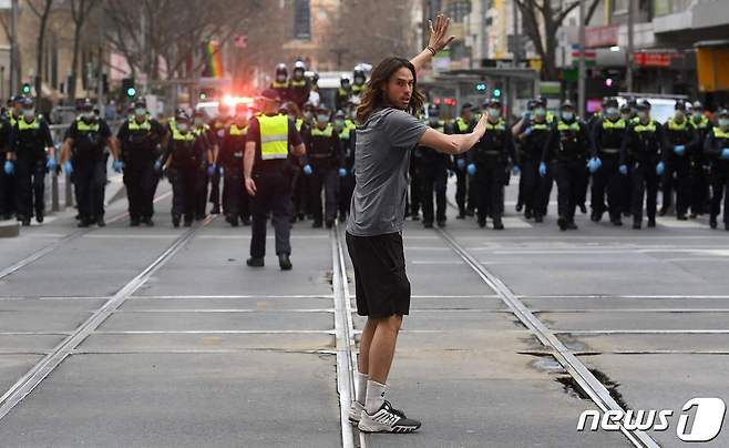 호주 멜버른에서 코로나19 6번째 봉쇄 조치에 반대하는 시위대가 경찰 앞에서 항의를 하고 있다. © AFP=뉴스1 © News1 우동명 기자