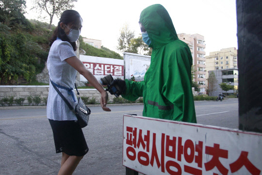 북한 평안남도 평성시에서 1일 한 보건 관계자가 주민의 체온을 측정하고 있다.      평성=AP 연합뉴스