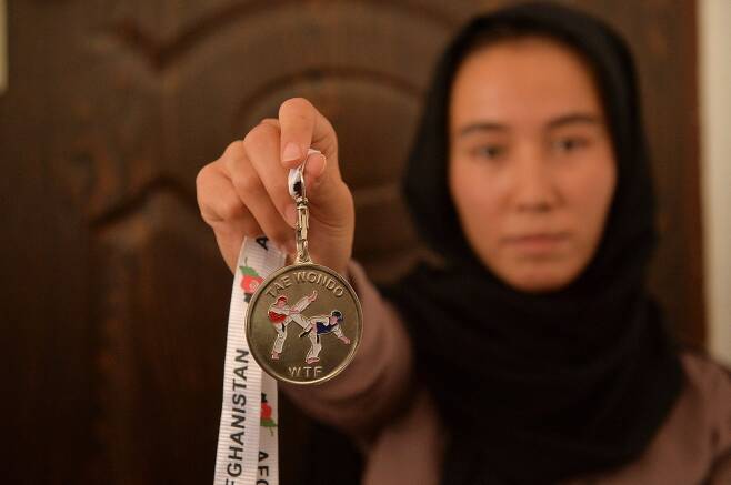 지난 21일(현지시간) 자르군나 누리가 아프가니스탄 헤라트주의 한 주택에서 태권도 챔피언 메달을 보여주고 있다. AFP=연합뉴스