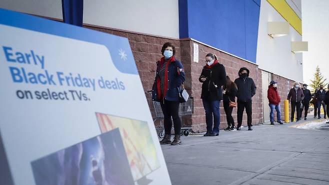 지난해 블랙프라이데이를 맞아 캐나다 앨버타주 캘거리의 한 전자제품 매장 앞에서 마스크를 착용한 쇼핑객들이 거리두기를 하며 줄을 서 있다. (사진=AP/연합뉴스 제공)