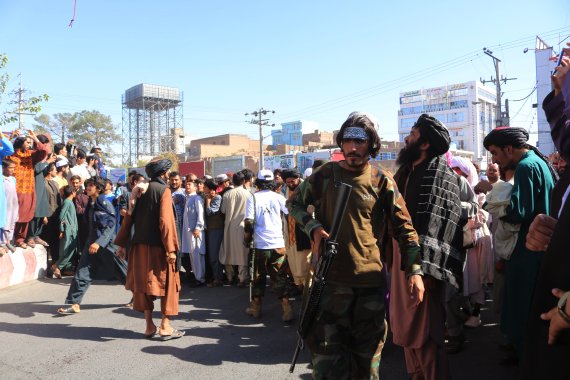 아프가니스탄 서부 헤라트에서 25일(현지시간) 중앙 광장에 모인 주민들이 탈레반에 의해 기중기로 공중에 전시된 시체들을 올려다 보고 있다.AP뉴시스