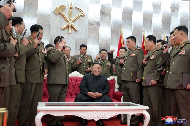 지난해 7월 김정은이 전승절 67주년을 맞아 주요 군 지휘관들에게 새로 개발한 ‘백두산’ 권총을 선물로 하사한 뒤 사진을 찍고 있다. 출처 : 조선중앙통신