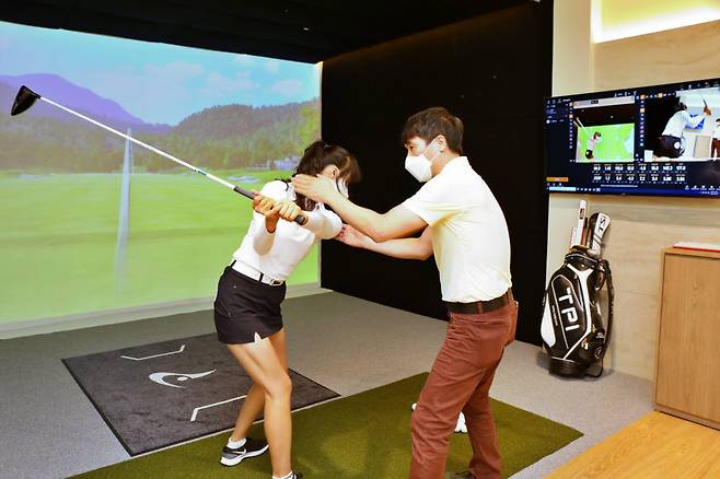 롯데백화점 잠실점 골프TPI 라운지에서 전문가가 골프 스윙 진단을 하고 있는 모습