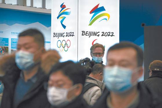 People wear face masks to protect against Covid-19 look at an exhibit at a visitors center at Winter Olympic venues in Yanqing on the outskirts of Beijing. Beijing Olympic organizers showed off the downhill skiing venue and the world’s longest bobsled and luge track last Friday, one year ahead of the opening of the 2022 Winter Games. [AP/YONHAP]