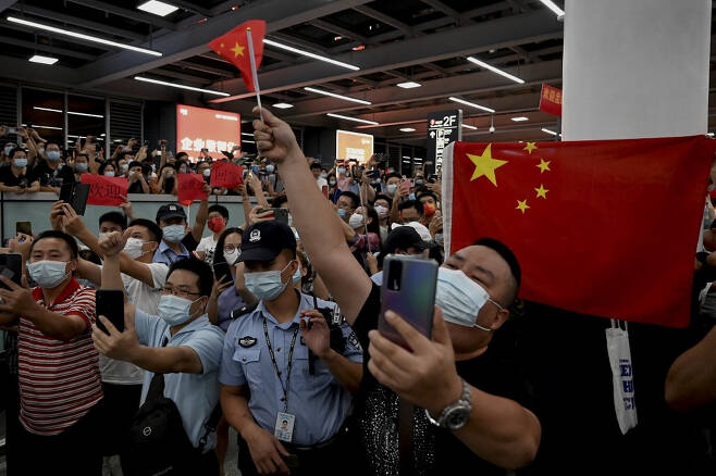 25일 선전 바오안 국제공항에서 중국 시민들이 멍 부회장의 귀국을 기다리며 오성홍기를 흔들고 있다./사진=AFP