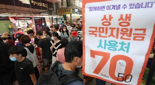 추석 전날인 지난 20일 오후 서울 망원시장의 한 점포에 국민지원금 이용 가능 안내문이 붙어 있다. 연합뉴스