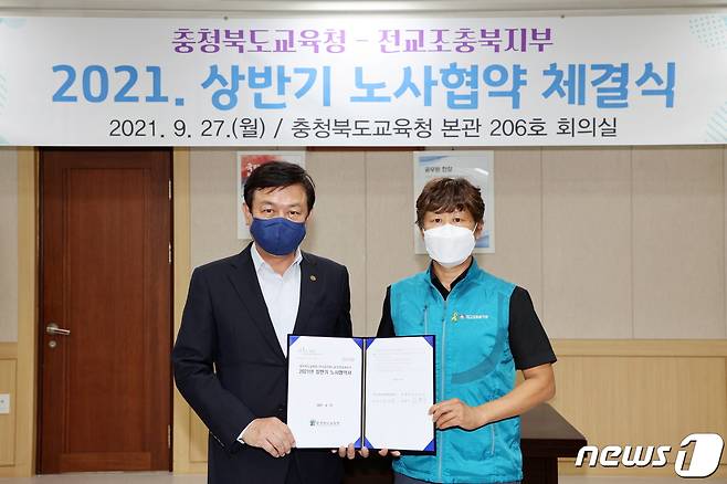 김병우 충북교육감(왼쪽)과 강창수 전교조 충북지부장이 노사협약을 체결한 뒤 기념촬영을 하고 있다.© 뉴스1