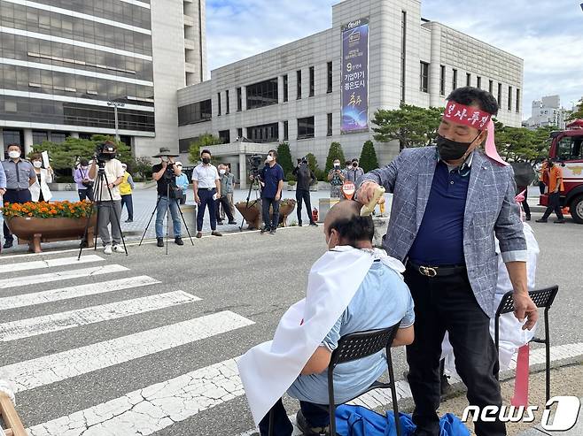 28일 신의섭 충북 충주시민참여연대 대표가 명성기 공동위원장 머리를 깍고 있다.2021.9.28/© 뉴스1