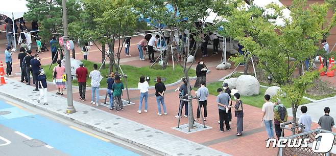 28일 대구지역 신종 코로나바이러스 감염증(코로나19) 확진자가 닷새째 100명대를 기록한 가운데 달성군보건소 선별진료소 앞에 지역 주민들과 외국인 근로자들이 줄지어 코로나19 진단검사를 기다리고 있다. 2021.9.28/뉴스1 © News1 공정식 기자