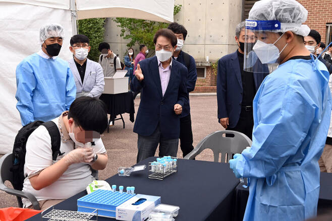 조희연(가운데) 서울시교육감이 28일 신속 자가분자진단 유전자증폭(신속 PCR) 검사소가 마련된 서울 종로구 동성고등학교를 방문해 신속 검사 과정을 살펴보고 있다.
