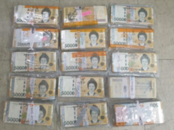 중고로 구매한 김치냉장고 외부 바닥에 붙어 있던 5만원권 지폐 1억1,000만 원. 제주경찰청 제공