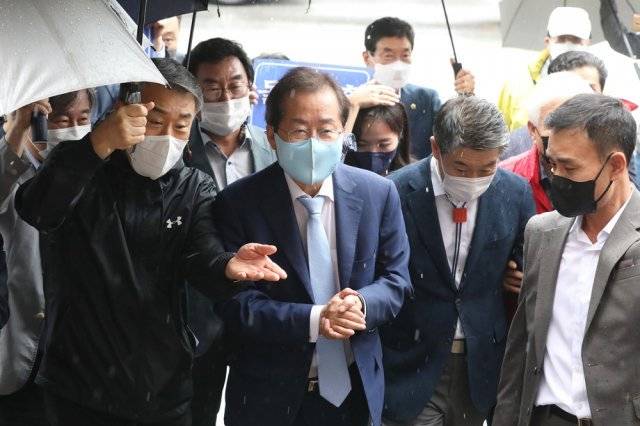 홍준표 국민의힘 대선 경선 예비후보가 29일 오후 비가 내리는 가운데 경북 영주시 풍기인삼시장에 도착해 시장 안으로 들어서고 있다. 2021.9.29/뉴스1