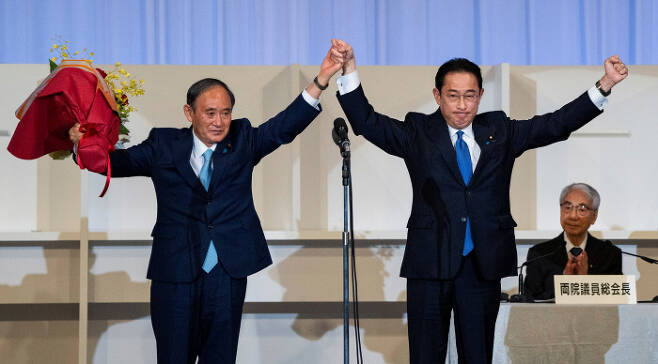 주먹 불끈 29일 치러진 일본 집권 여당 자민당의 신임 총재 선거에서 승리해 일본의 새 총리가 된 기시다 후미오 전 자민당 정무조사회장(오른쪽)이 스가 요시히데 전 총리와 맞잡은 두 손을 들어올리며 승리를 자축하고 있다. 의원내각제인 일본에서는 집권당 총재가 총리를 맡는다. 도쿄 | 로이터연합뉴스