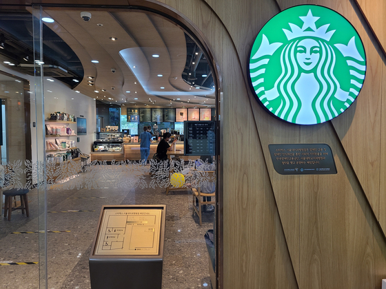 In front of a Starbucks coffee shop at Seoul National University Dental Hospital are a braille guide to the interior of the shop and a plaque that says a disabled person work there. [CHUNG HEE-YUN]