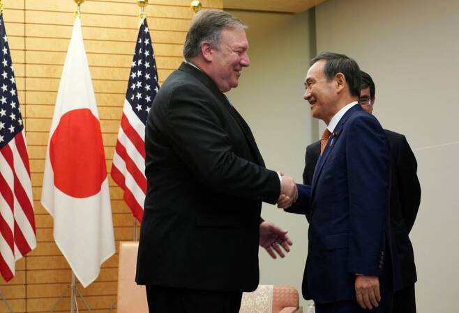 스가 요시히데 일본 총리가 마이크 폼페이오 미국 전 국무부 장관과 만나 악수하고 있다./사진=AFP