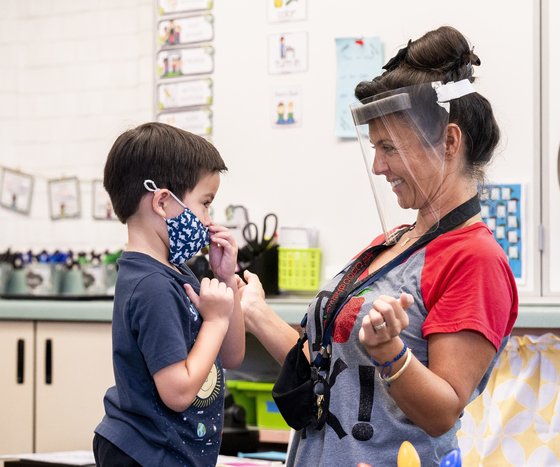 미국 캘리포니아 터스틴의 한 유치원에서 교사가 학생의 마스크를 고쳐주고 있다. 스콧 고틀립 전 FDA 국장은 5~11세 어린이용 코로나19 백신의 긴급 사용 승인 시점이 11월 중순이 될 수도 있다고 29일 이야기했다. [AP=연합뉴스]