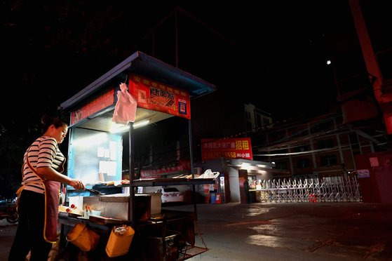 30일 전력난 사태가 중국 전역으로 확산하는 가운데 중국 남부 광둥성 둥관시의 공업단지 입구에서 상인이 바비큐를 요리하고 있다. [AFP 연합]